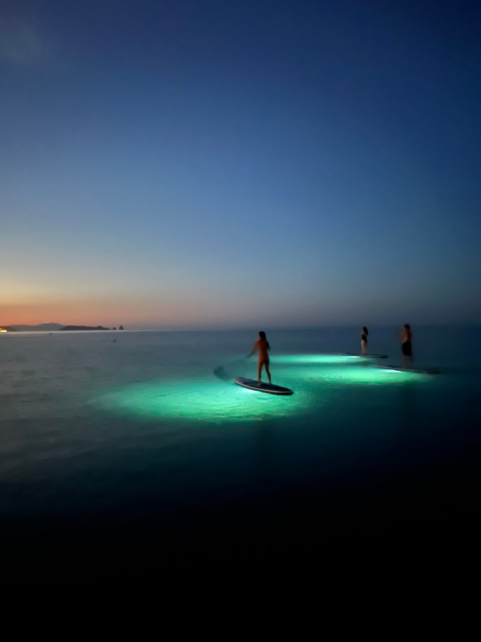 Sunset on a paddle surf board with lights in begur pantai costa brava