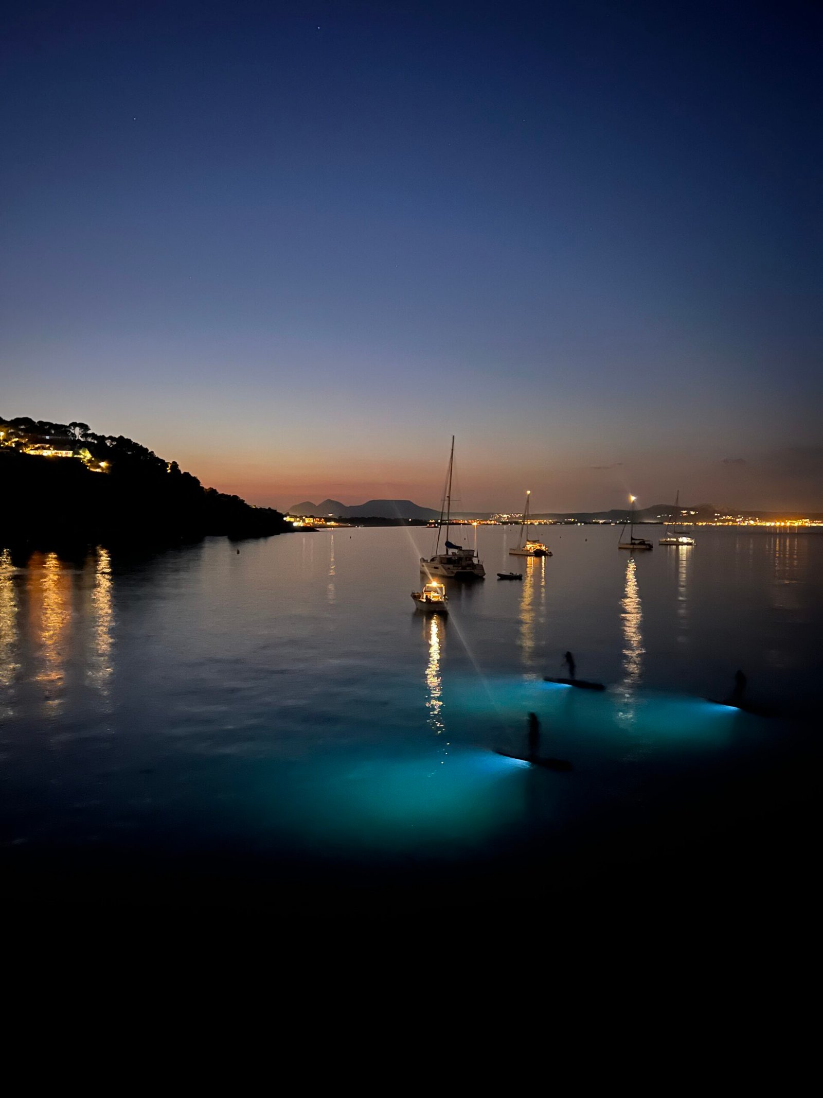 Sunset on a paddle surf board with lights in begur pantai costa brava